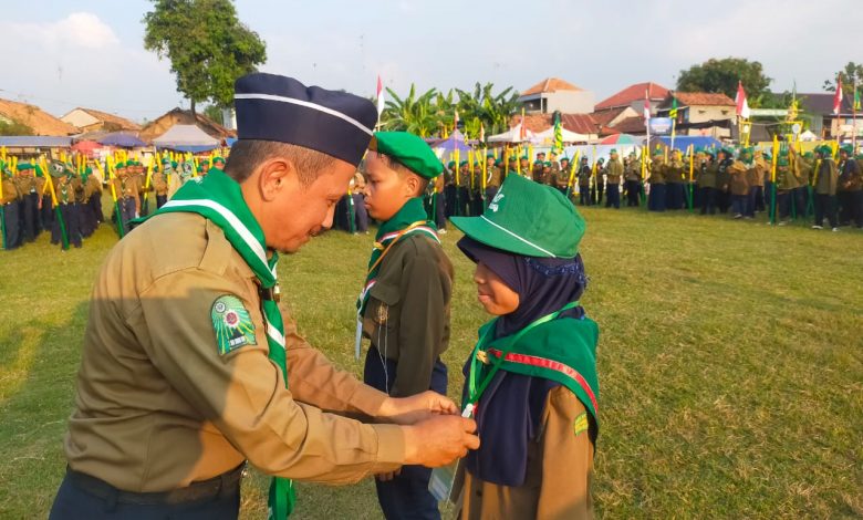 Wakil Ketua Muhammadiyah Kabupaten Pekalongan, Drs. H. Riyanto, M. Pd, menyematkan tanda peserta jambore pengenal Hizbul Wathan SD-MI Muhammadiyah se-Kabupaten Pekalongan