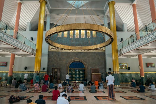 Interior view of a mosque in Yogyakarta, Indonesia, showcasing a group in prayer.